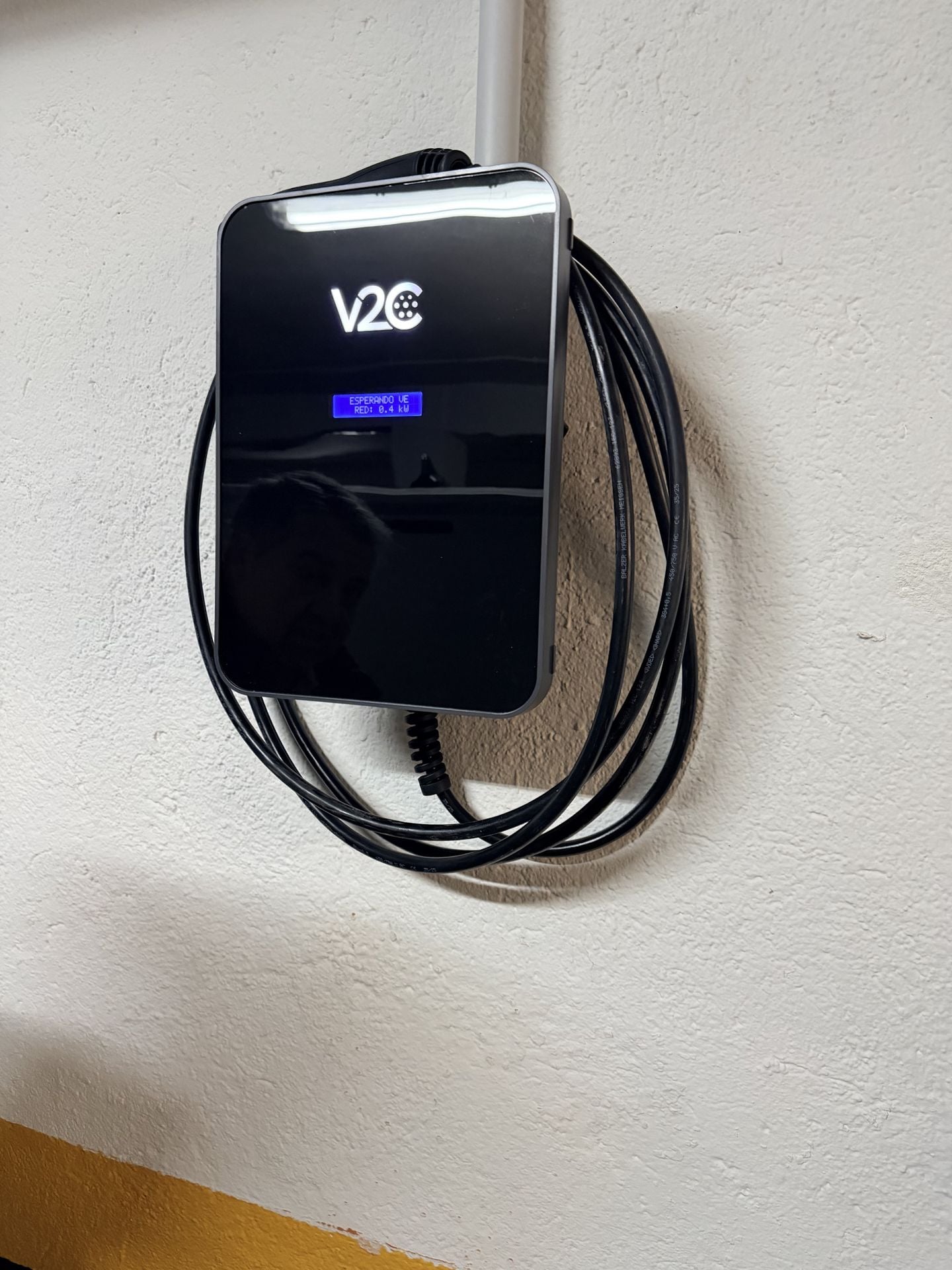 V2C cargador en pared blanca instalacion limpia